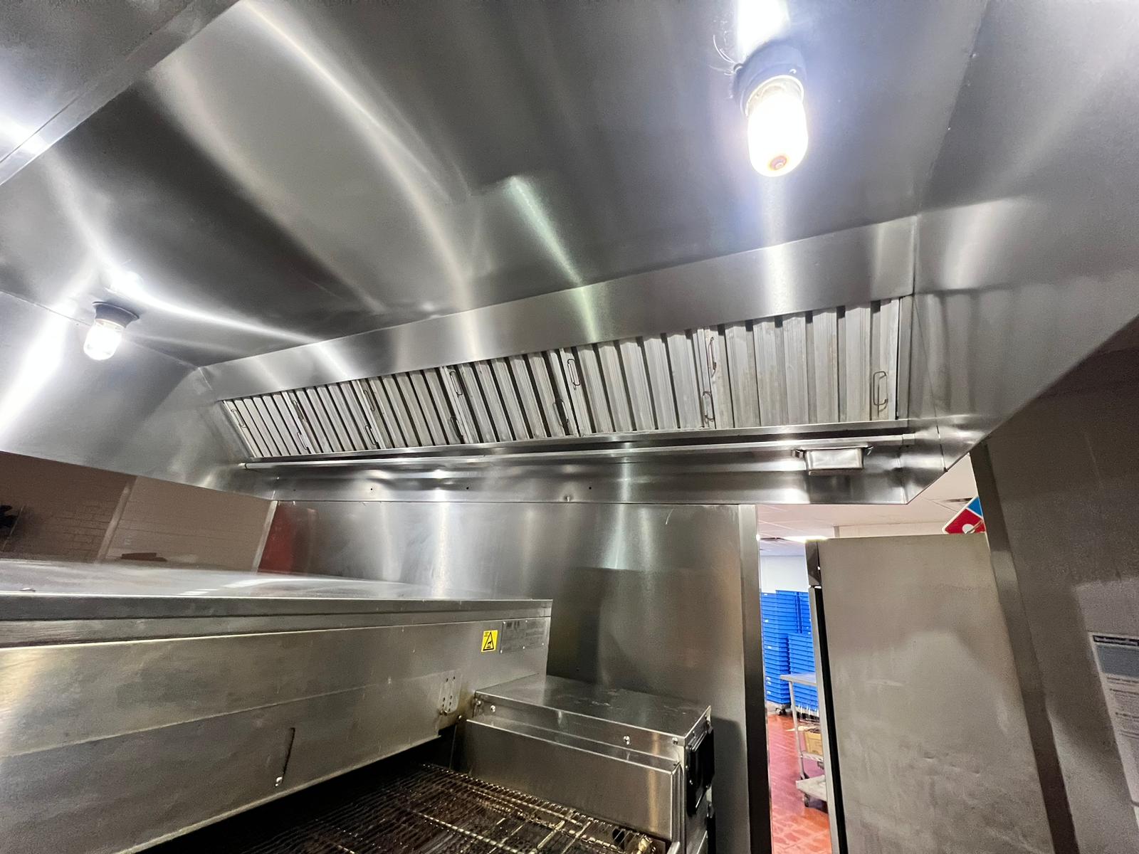 Chef cooking on a restaurant range beneath an exhaust hood