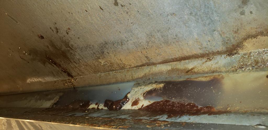 Chef cooking on a restaurant range beneath an exhaust hood