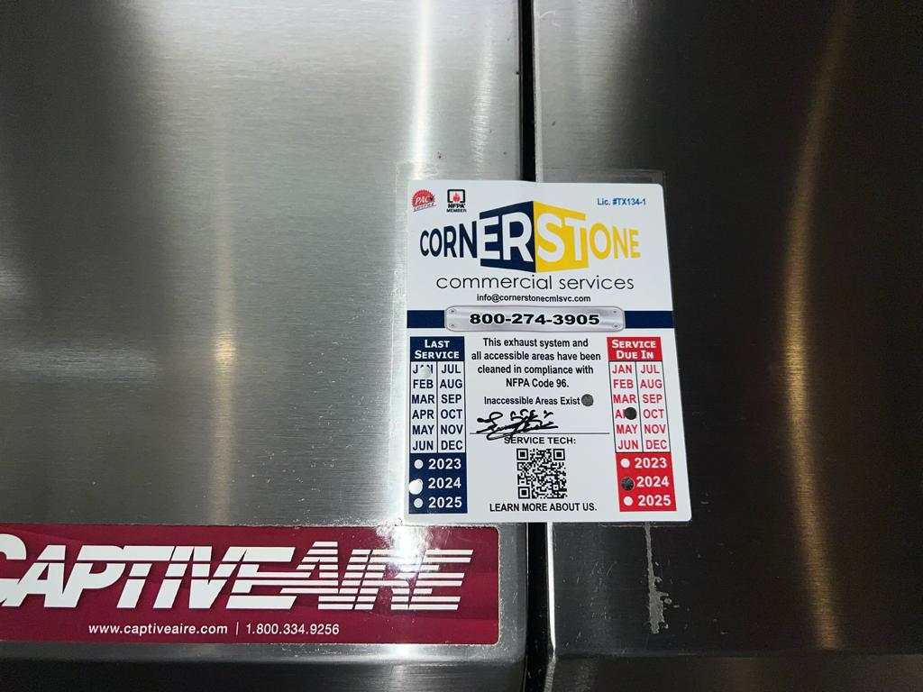 Chef cooking on a restaurant range beneath an exhaust hood