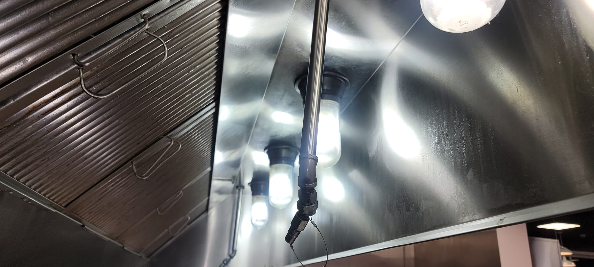 Stainless steel hood over a commercial kitchen cook line