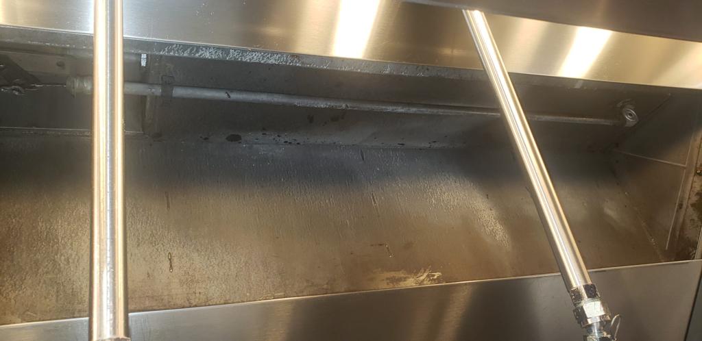 Chef cooking on a restaurant range beneath an exhaust hood