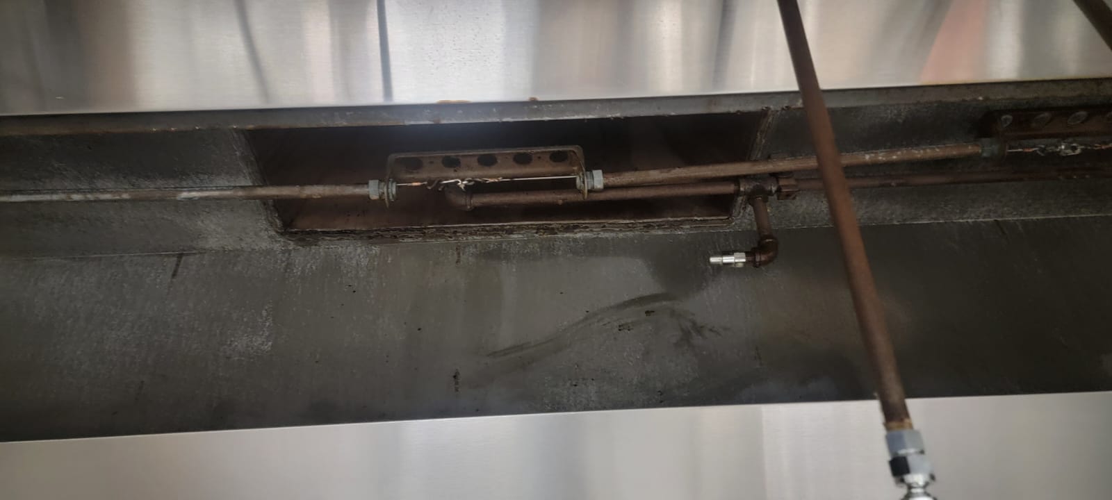 Chef cooking on a restaurant range beneath an exhaust hood