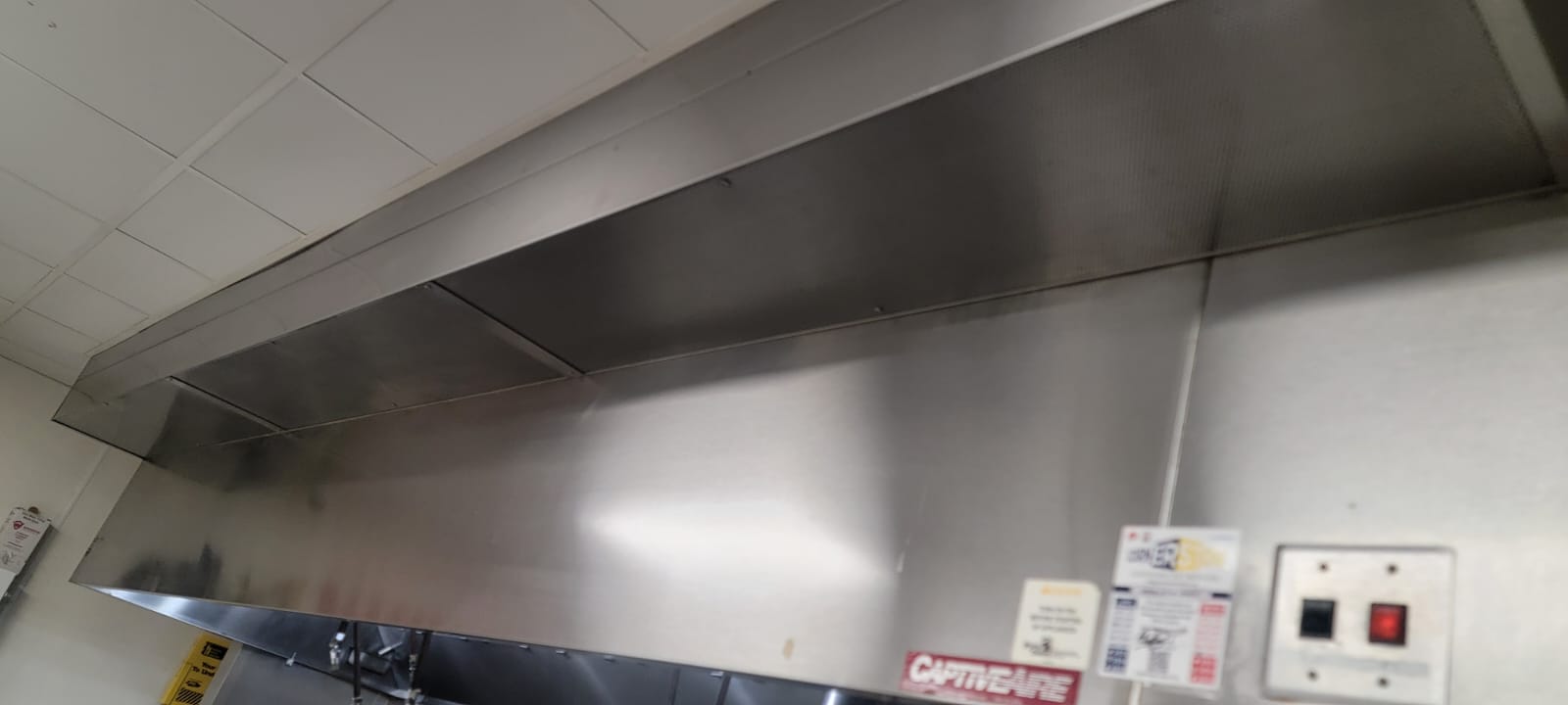 Chef cooking on a restaurant range beneath an exhaust hood
