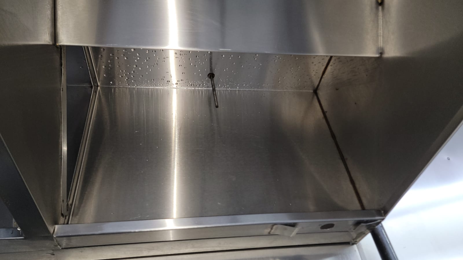 Chef cooking on a restaurant range beneath an exhaust hood
