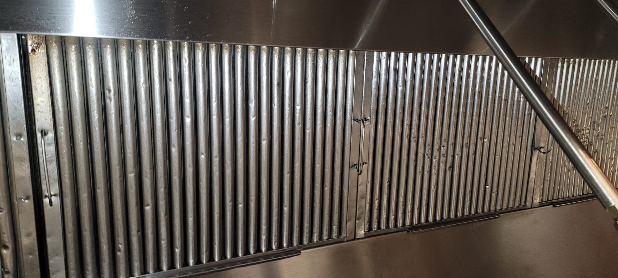 Chef cooking on a restaurant range beneath an exhaust hood