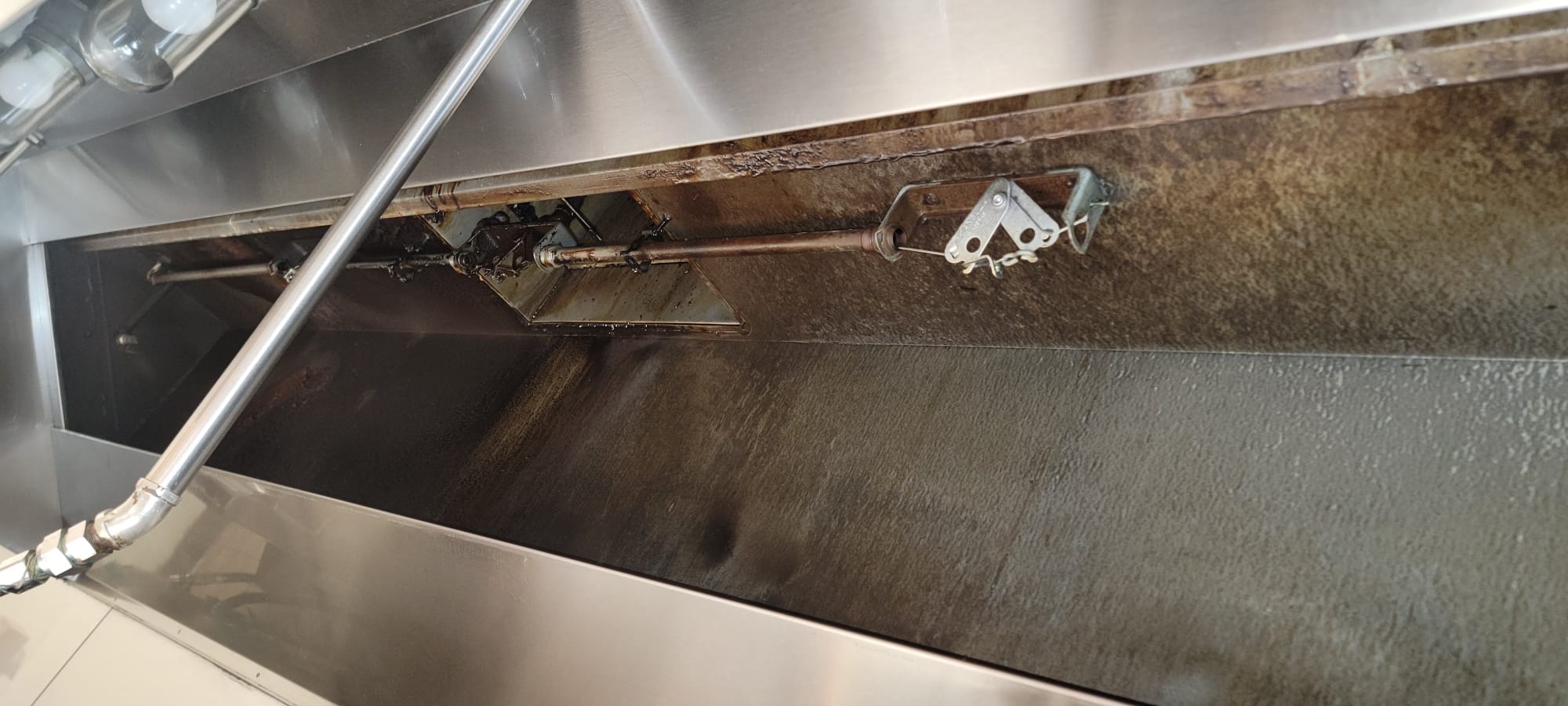 Chef cooking on a restaurant range beneath an exhaust hood
