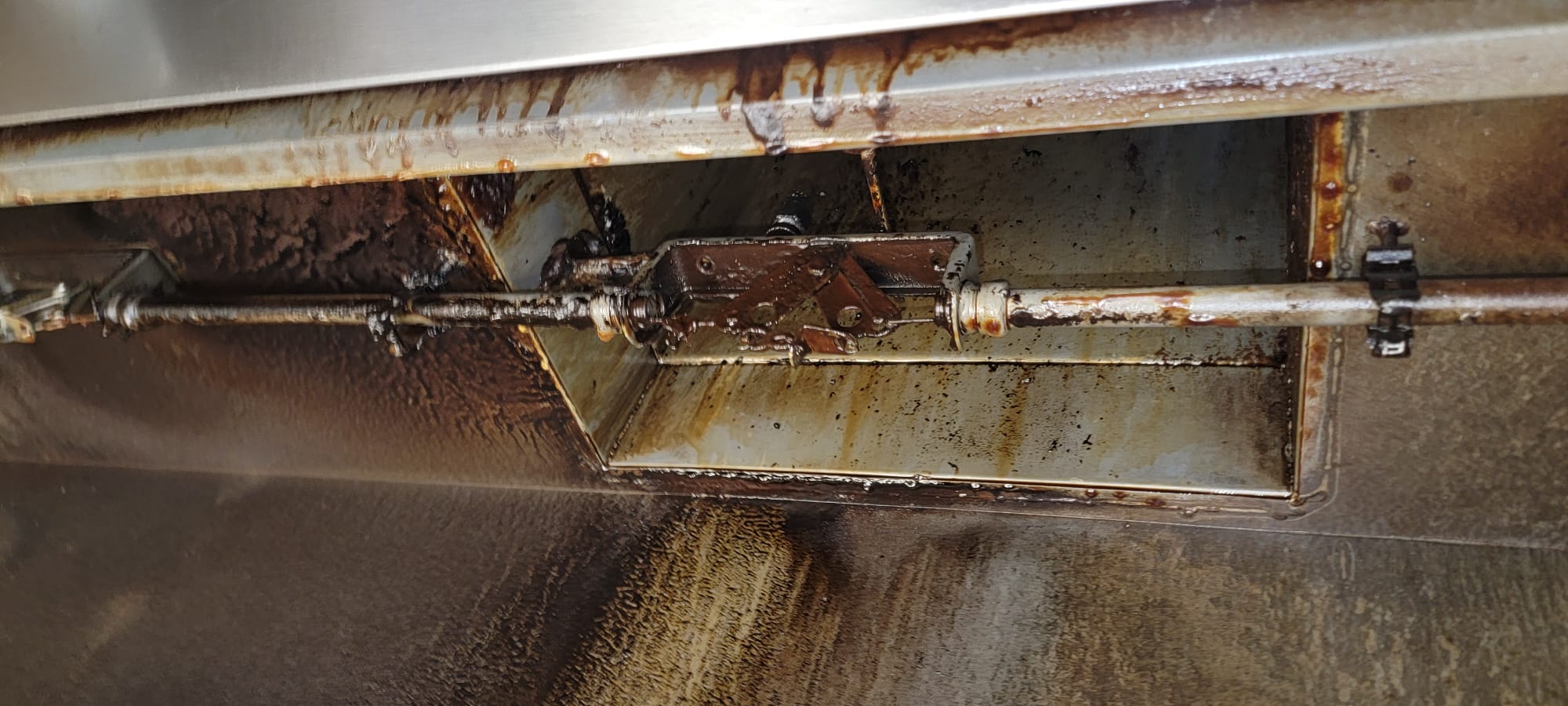 Chef cooking on a restaurant range beneath an exhaust hood