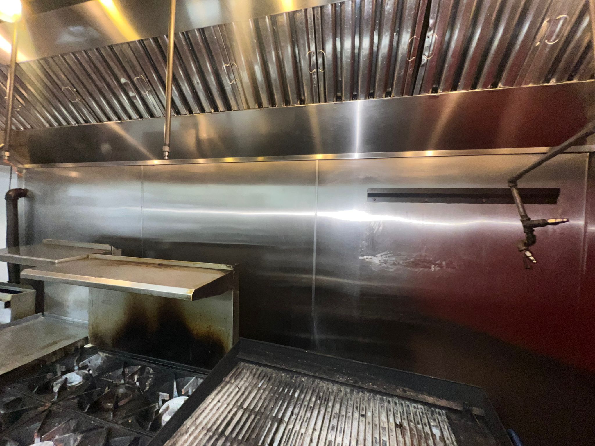 Chef cooking on a restaurant range beneath an exhaust hood