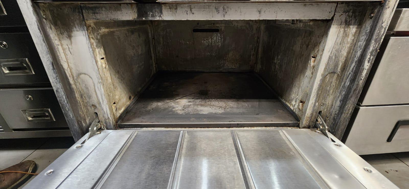 Chef cooking on a restaurant range beneath an exhaust hood