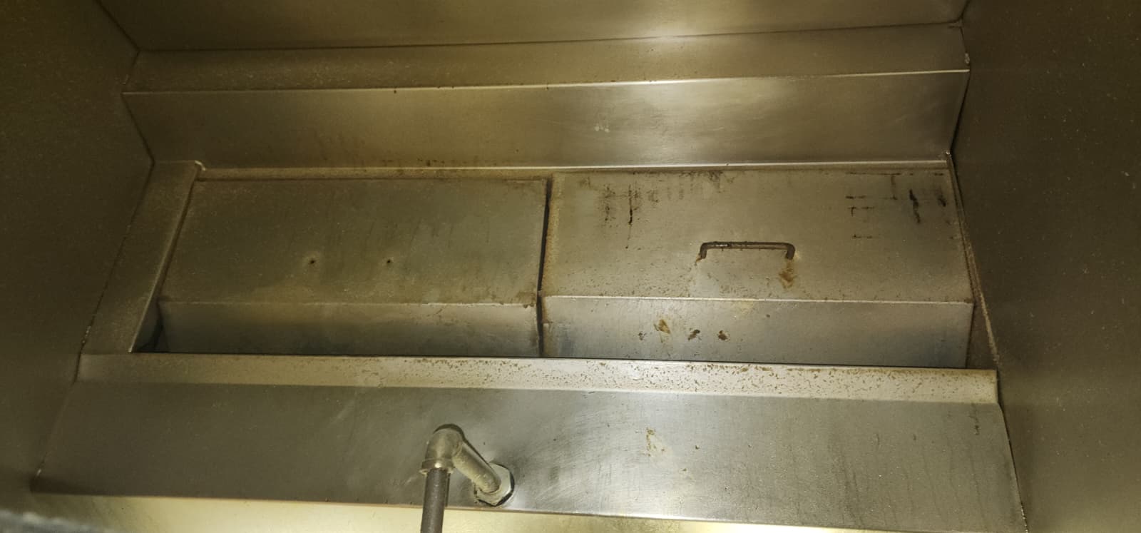 Chef cooking on a restaurant range beneath an exhaust hood